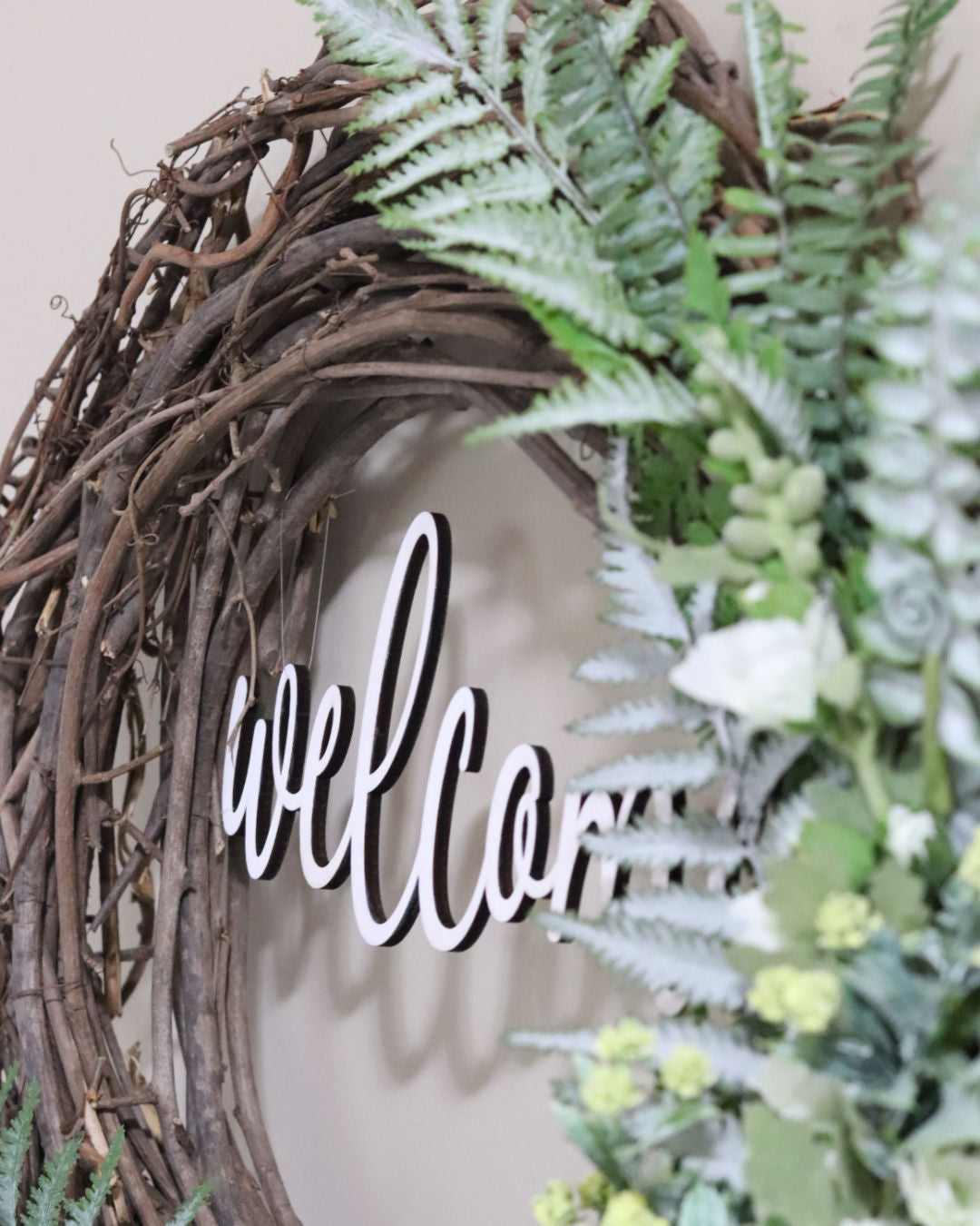 Welcome White Hollyhock and Yellow Ranunculus Fern Wreath