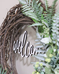 Welcome White Hollyhock and Yellow Ranunculus Fern Wreath